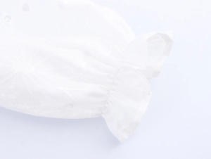 Détail de la manche en coton brodé blanc avec poignet à volants et bande élastique