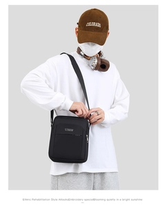 Detailed view of the men's black waterproof crossbody bag with front zipper and strap
