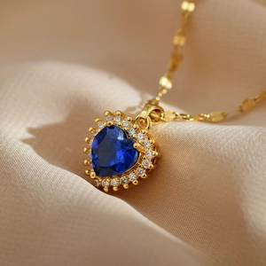 Detailed view of heart-shaped sapphire blue zircon pendant on gold-plated chain