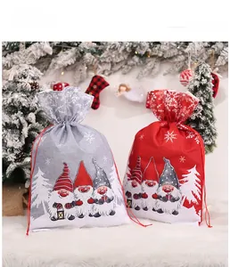 Close-up of Christmas drawstring gift bags featuring festive gnome prints and snowflakes