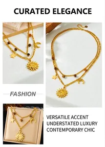 Detail of layered gold necklace with sun, moon, star charms and brown tiger eye beads