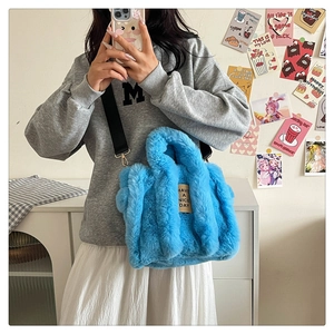 Close-up of bright blue plush tote bag with soft faux fur texture and adjustable strap