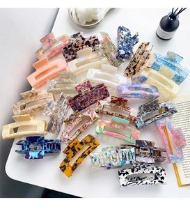 Detailed top view of various acetate leopard print hair claws on a stylish desk