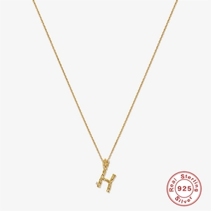 Close-up of S925 silver golden H letter necklace with branch texture and cubic zirconia