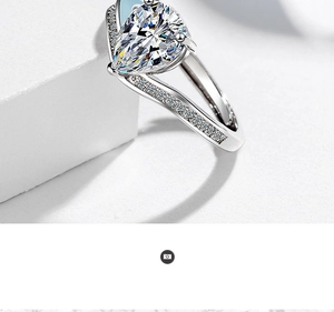 Macro detail of a pear-cut cubic zirconia ring with small diamonds on a geometric stand