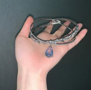 Macro shot of silver multi-layer rhinestone choker with purple teardrop pendant charm