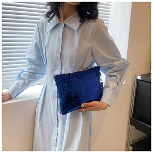 Detailed close-up of dark blue sequin clutch bag showing texture and metallic shimmer