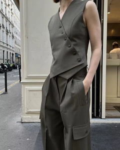 Detail of olive green asymmetric vest and cargo pants set in twill fabric texture