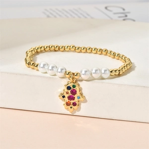 Detail of beaded bracelet with gold beads, pearls, and colorful zircon Hamsa hand pendant