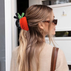 Carrot hair claw clip shown on a model with warm lighting and minimalist background