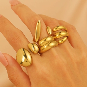 Close-up of chunky 18K gold plated lava rings with geometric fluid design on satin