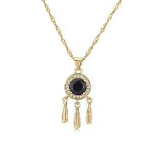 Detail of 18K gold plated necklace with black zircon pendant and three feather charms