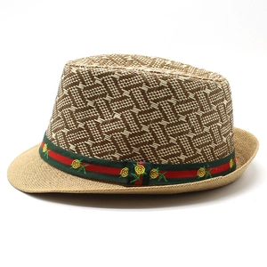 Detail of woven straw fedora with green-red striped ribbon and floral embroidery