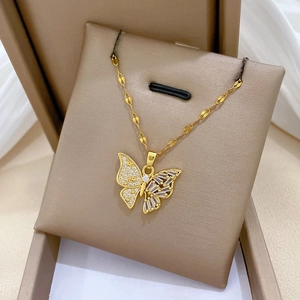 Vue détaillée du collier papillon doré serti de zircons sur son support luxueux