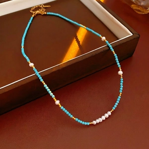 Bohemian style necklace with turquoise beads and freshwater pearls on elegant leather tray