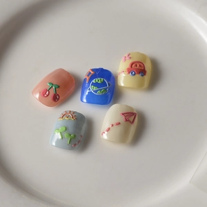 Close-up of 3D embossed cartoon press-on nails in various colors on ceramic plate