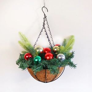 Weihnachts-Hängekorb mit Kiefernzweigen und bunten Ornamenten auf weißem Hintergrund