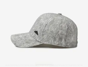 Detail view of the gray mottled texture fabric and mountain metal logo on baseball cap