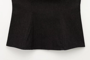 Dettaglio macro del tessuto denim nero e cuciture dell'orlo per questo capo d'abbigliamento
