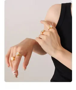 Detailed view of gold plated titanium rings with white shell inlays on hands