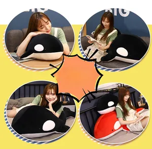 Detailed view of plush orca pillows in black and orange used as cozy home cushions