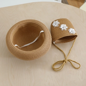 Detail of children's straw hat with elastic chin strap and matching lace flower crossbody bag