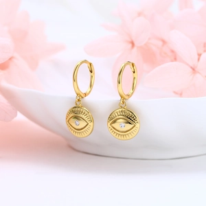 S925 sterling silver gold devil's eye hoop earrings with zircon on a white ceramic bowl