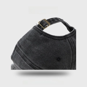 Detail of baseball cap back with adjustable bronze metal buckle on washed denim fabric