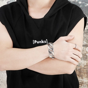Close-up of 24mm wide polished silver Cuban link bracelet on a male model's wrist