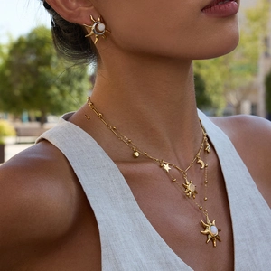 Dettaglio del set collana e orecchini a sole in oro 18K con ciondolo in pietra di luna