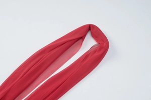 Detail showing the lightweight red mesh tulle fabric with a soft and transparent texture