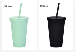 Close-up of matte 16oz double-wall plastic tumblers in green and black colors with straws