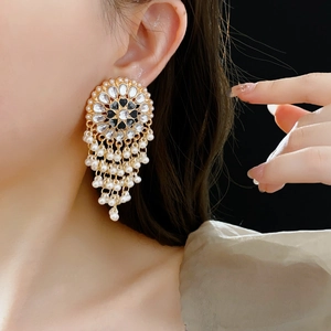 Detail of vintage heart pearl earring featuring gold metal, rhinestones and black enamel