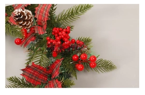 Détail d'une branche de Noël avec baies rouges, pommes de pin et feuilles à carreaux