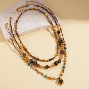 Retro multi-layer tiger eye beaded necklace with heart pendant on natural stone display