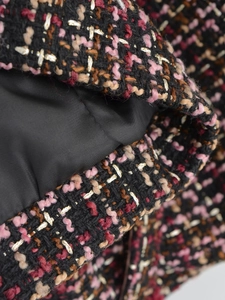 Macro view of multi-color tweed fabric texture with premium black satin lining detail