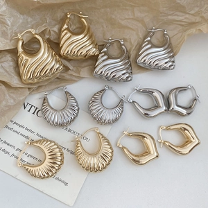 Retro hollow heart and geometric earrings in gold and silver finish on artistic paper