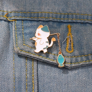 Cute cartoon cat fishing enamel pin on denim jacket, creative animal brooch badge