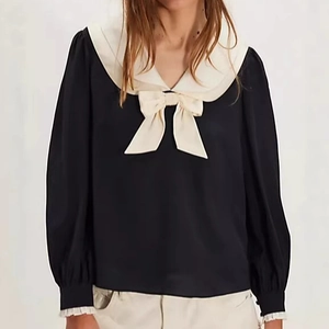 Detail of French style black chiffon blouse featuring white bowknot and sailor collar