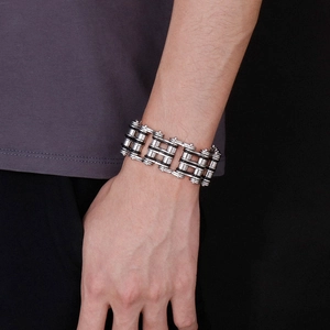 Close-up of a silver and black mechanical chain bracelet worn on a man wrist