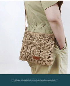 Detail of hollow woven paper rope beach bag with brown leather strap and logo patch