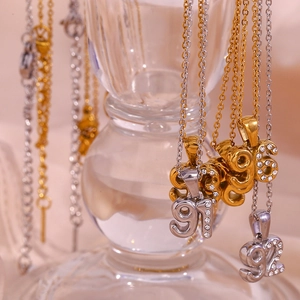 Close-up of 18K gold plated year necklaces featuring micro-inlaid sparkling zircons