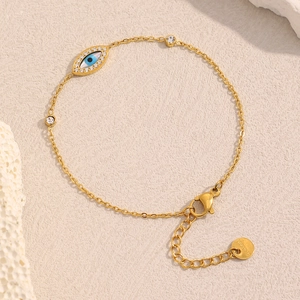 Detailed macro shot of 18K gold-plated evil eye bracelet with white crystal inlays