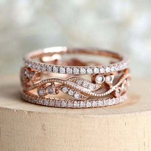 Macro shot of rose gold rings with intricate vine patterns and micro-set cubic zirconia stones