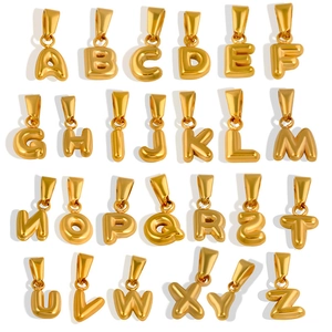 Macro shot of 26 gold-plated 3D bubble letter pendants from A to Z on white background