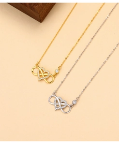 Macro detail of gold and silver infinity heart necklaces with micro-pave zirconia
