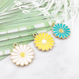 Three enamel daisy flower charms in white yellow and turquoise with gold trim