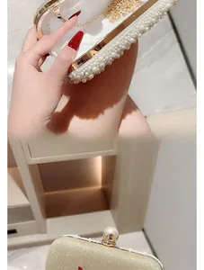 Detailed macro view of champagne sequins and white pearl decor on an evening clutch bag