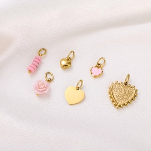 Detailed view of six gold and pink heart pendants on white silk background