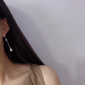 Eleganti orecchini lunghi in argento con nappe e perle d'acqua dolce su una modella